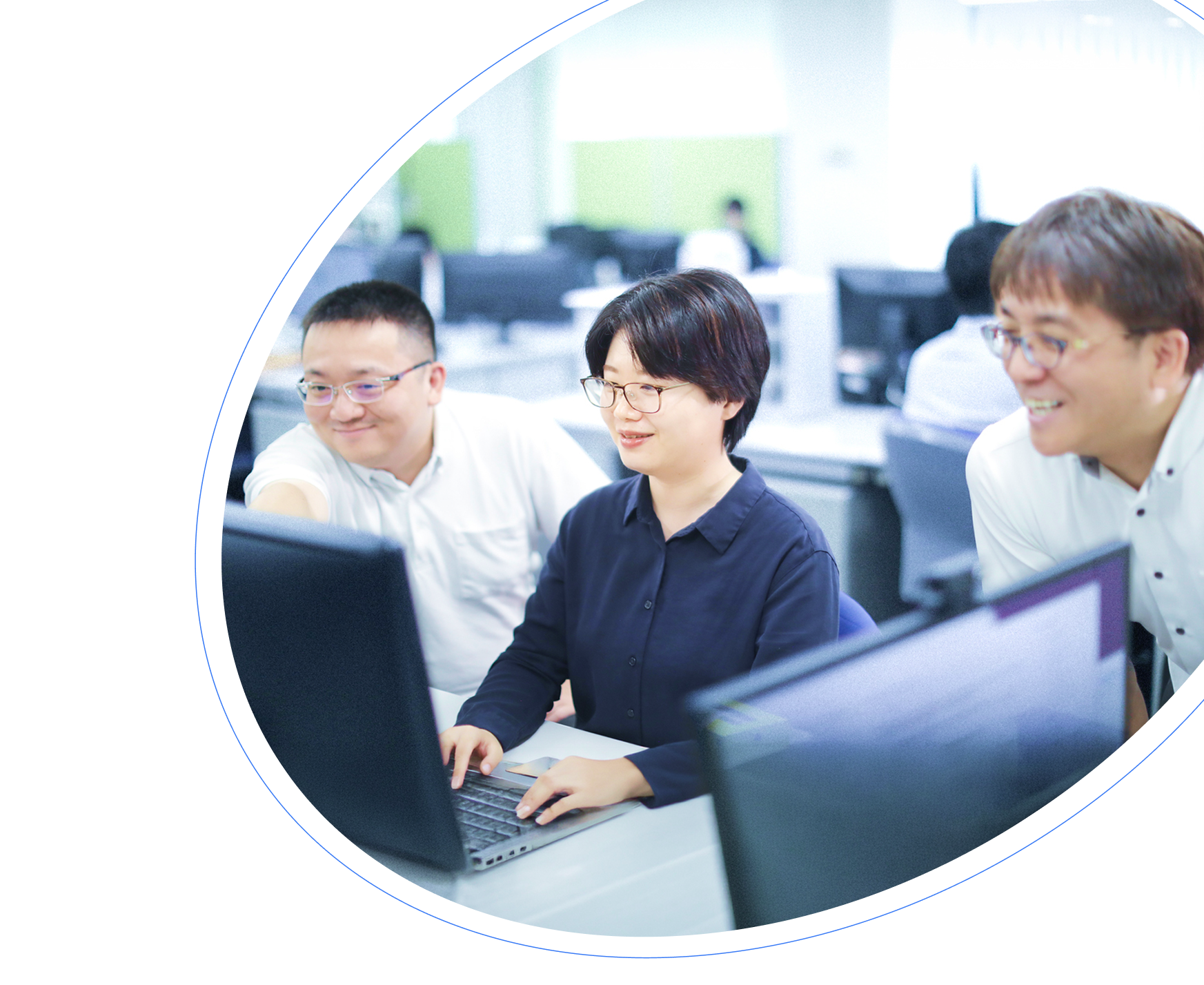 PCの前で談笑する3人の社員