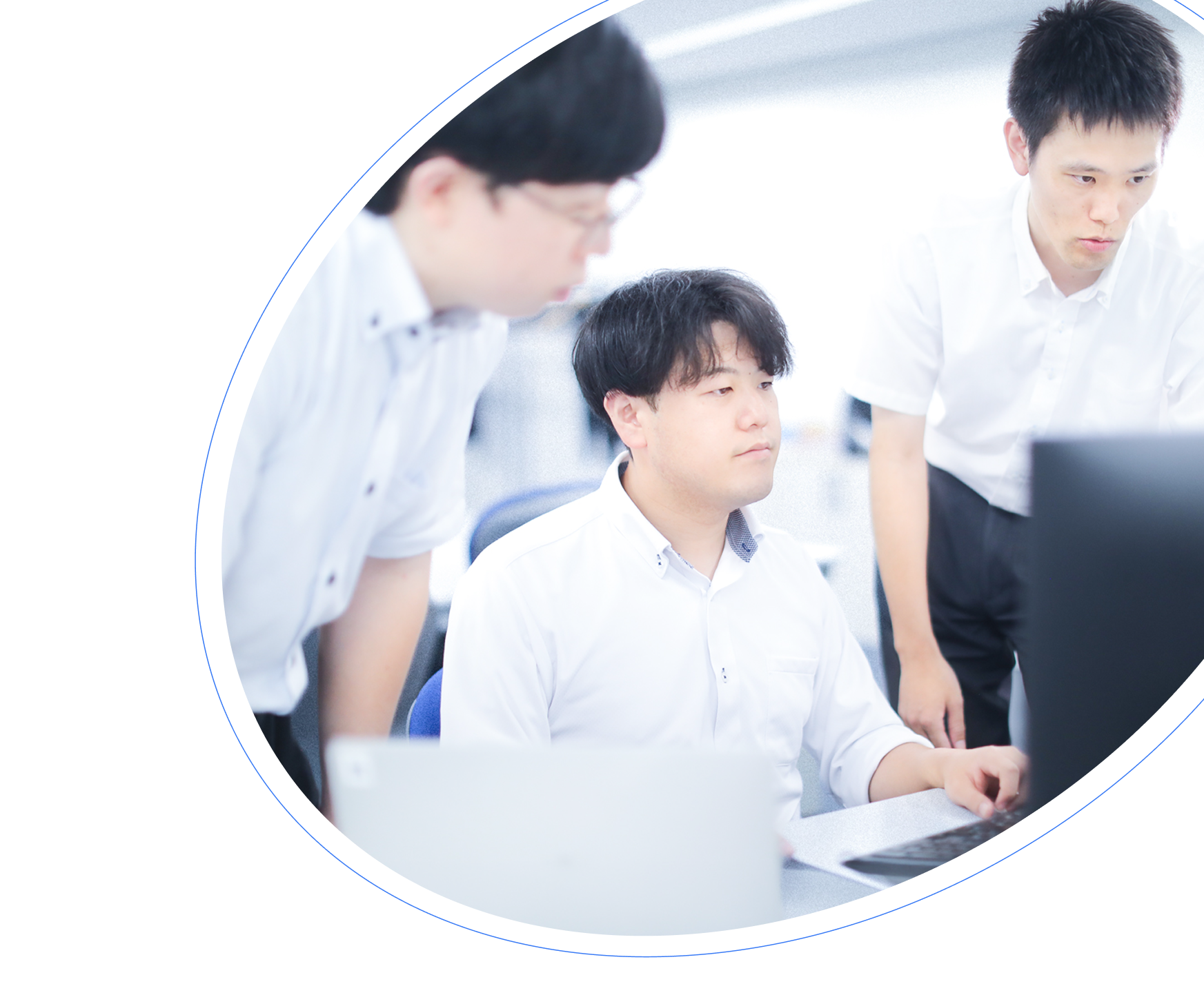 画面を見ながら打ち合わせをする社員