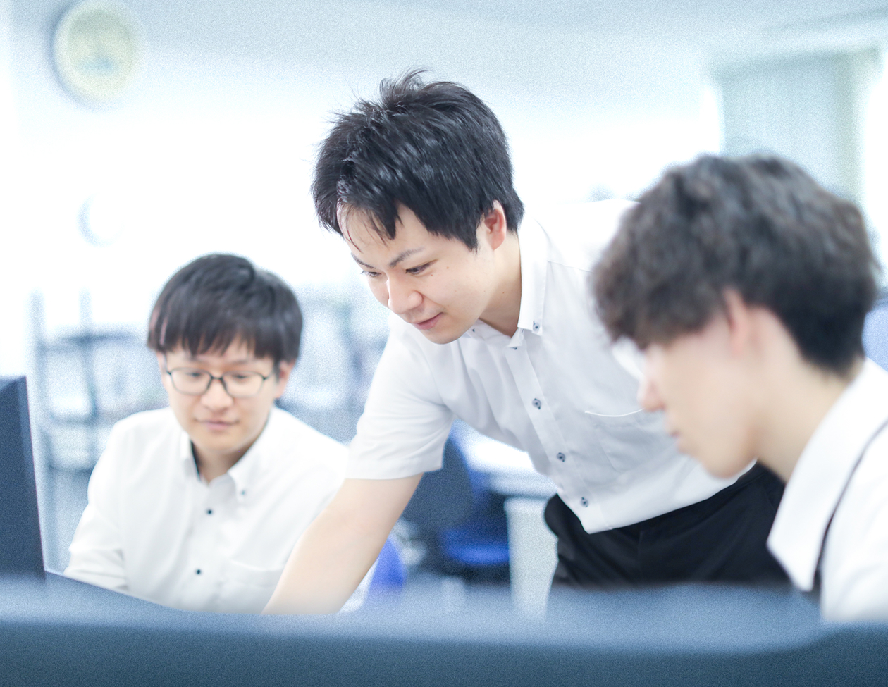 PCの画面を囲んで話し合う3人の社員